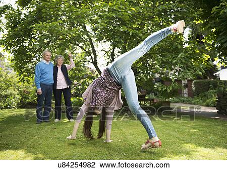 Grandparents and granddaughter doing acrobatics in garden View Large Photo Image Stock Image - Grandparents and granddaughter doing acrobatics in garden. Fotosearch