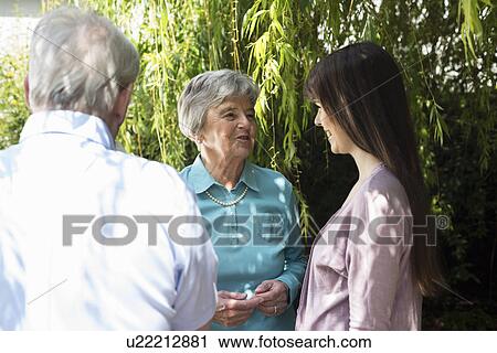 Grandparents and granddaughter having conversation in garden View Large Photo Image Stock Image - Grandparents and granddaughter having conversation in garden. Fotosearch