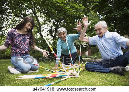 Grandparents and granddaughter playing giant pick up sticks View Large Photo Image Stock Photo - Grandparents and granddaughter playing giant pick up sticks. Fotosearch