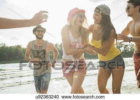 Group of friends playing in lake View Large Photo Image Stock Image - Group of friends playing in lake. Fotosearch