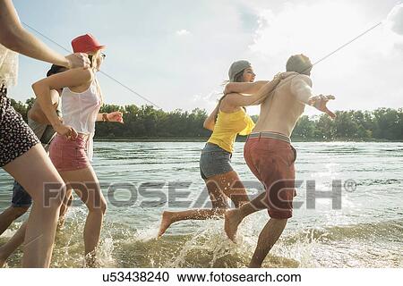 Group of friends running in lake View Large Photo Image Stock Image - Group of friends running in lake. Fotosearch