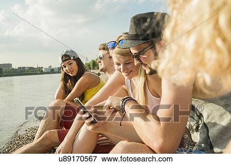 Group of friends using smartphone View Large Photo Image Stock Photo - Group of friends using smartphone. Fotosearch