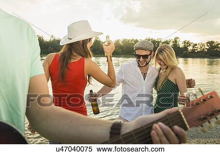 Group of friends with beer, guitar in foreground View Large Photo Image Stock Photography - Group of friends with beer, guitar in foreground. Fotosearch