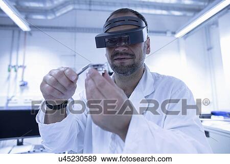 Lab assistant fixing part View Large Photo Image Stock Photo - Lab assistant fixing part. Fotosearch