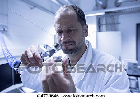 Lab assistant fixing part View Large Photo Image Stock Photograph - Lab assistant fixing part. Fotosearch