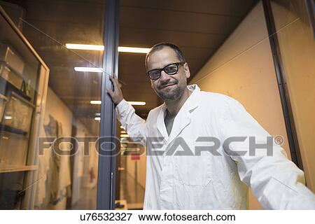 Lab assistant standing by glass door View Large Photo Image Stock Photo - Lab assistant standing by glass door. Fotosearch