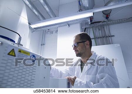 Lab assistant working on equipment View Large Photo Image Picture - Lab assistant working on equipment. Fotosearch
