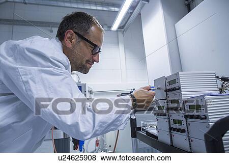 Stock Photo - Lab assistant working on equipment. Fotosearch