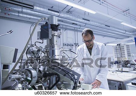 Lab assistant working on equipment View Large Photo Image Stock Photo - Lab assistant working on equipment. Fotosearch