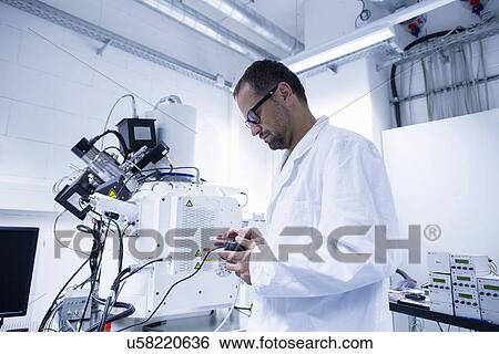 Lab assistant working on equipment View Large Photo Image Stock Photograph - Lab assistant working on equipment. Fotosearch