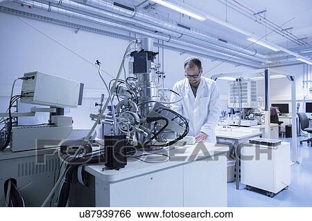 Lab assistant working on equipment View Large Photo Image Stock Photograph - Lab assistant working on equipment. Fotosearch