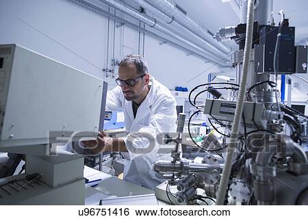 Lab assistant working on equipment View Large Photo Image Stock Photograph - Lab assistant working on equipment. Fotosearch