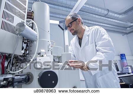Lab assistant working on microscope View Large Photo Image Stock Image - Lab assistant working on microscope. Fotosearch