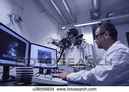 Picture - Lab assistant working with SEM image on computer. Fotosearch