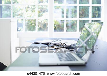 Stock Image - Laptop and diary on dining room table. Fotosearch