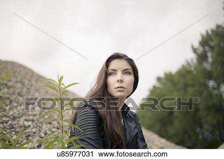 Low angle portrait of beautiful young woman gazing View Large Photo Image Stock Image - Low angle portrait of beautiful young woman gazing. Fotosearch