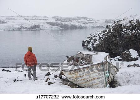 Stock Image - Man by lake, Iceland. Fotosearch