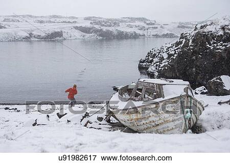Stock Photo - Man by lake, Iceland. Fotosearch