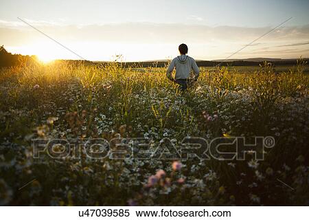 Man enjoying sunset on field, Sarsy village, Sverdlovsk region, Russia View Large Photo Image Stock Photography - Man enjoying sunset on field, Sarsy village, Sverdlovsk region, Russia. Fotosearch
