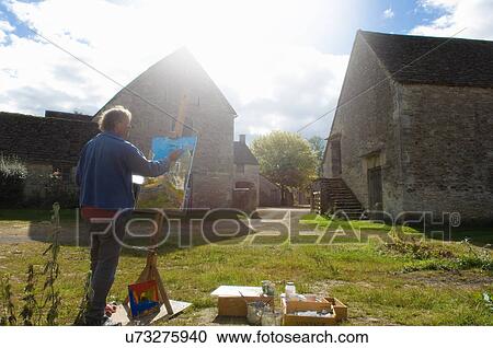 Man oil painting at easel outside farm buildings View Large Photo Image Stock Image - Man oil painting at easel outside farm buildings. Fotosearch