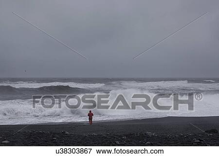 Stock Photo - Man on beach, Vik, Iceland. Fotosearch