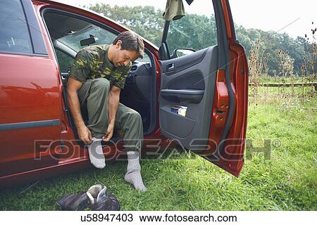 Man sitting in car putting on socks View Large Photo Image Stock Image - Man sitting in car putting on socks. Fotosearch