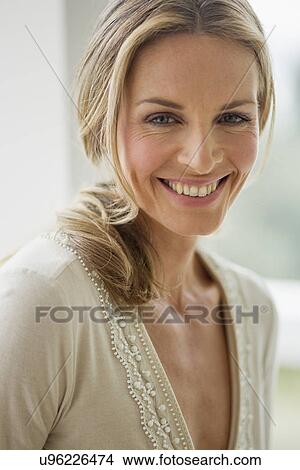 Mature blonde woman looking at camera smiling, portrait View Large Photo Image Picture - Mature blonde woman looking at camera smiling, portrait. Fotosearch