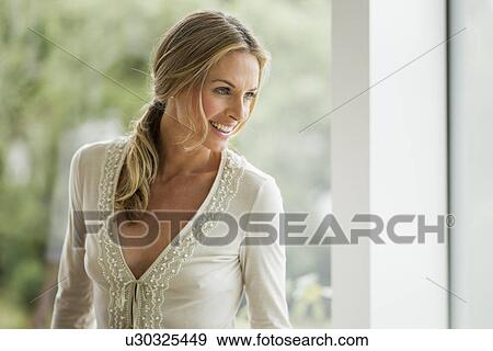 Stock Photo - Mature blonde woman looking away, portrait. Fotosearch