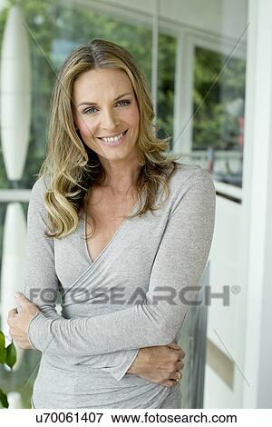 Stock Photo - Mature blonde woman smiling, portrait. Fotosearch