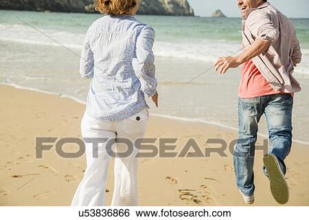 Mature couple running on beach, Camaret-sur-mer, Brittany, France View Large Photo Image Stock Photograph - Mature couple running on beach, Camaret-sur-mer, Brittany, France. Fotosearch