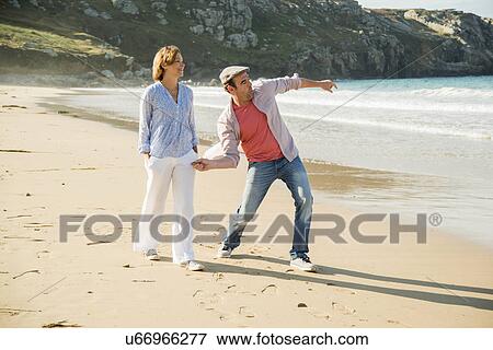 Mature couple throwing pebbles out to sea, Camaret-sur-mer, Brittany, France View Large Photo Image Stock Photo - Mature couple throwing pebbles out to sea, Camaret-sur-mer, Brittany, France. Fotosearch