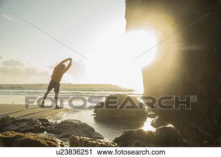 Mature man exercising on beach, looking out to sea View Large Photo Image Stock Image - Mature man exercising on beach, looking out to sea. Fotosearch