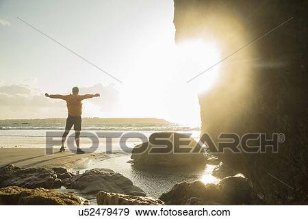 Mature man exercising on beach, looking out to sea View Large Photo Image Stock Photo - Mature man exercising on beach, looking out to sea. Fotosearch
