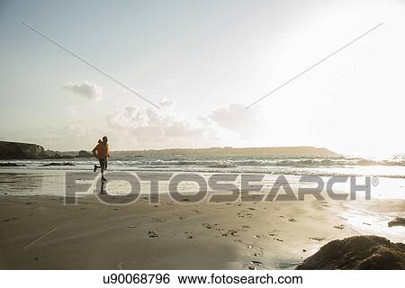Mature man running on sand, along coastline View Large Photo Image Stock Photograph - Mature man running on sand, along coastline. Fotosearch