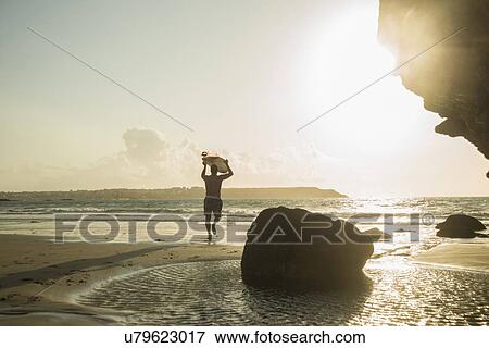 Mature man running towards sea, holding surf board View Large Photo Image Stock Photo - Mature man running towards sea, holding surf board. Fotosearch