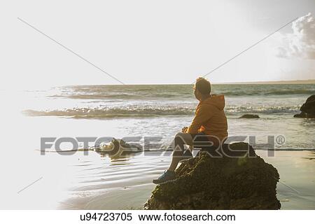 Mature man, sitting on rock, looking out to sea View Large Photo Image Stock Photography - Mature man, sitting on rock, looking out to sea. Fotosearch