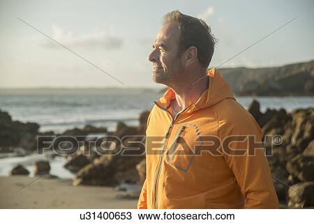 Mature man, standing on beach, looking out to sea View Large Photo Image Stock Image - Mature man, standing on beach, looking out to sea. Fotosearch
