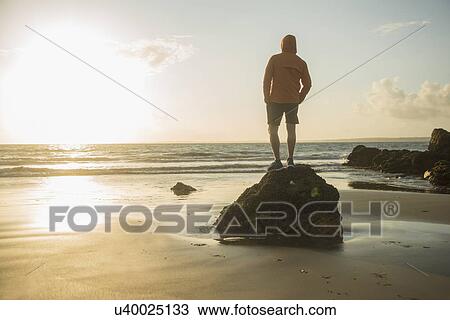 Mature man, standing on rock, looking out to sea View Large Photo Image Stock Image - Mature man, standing on rock, looking out to sea. Fotosearch