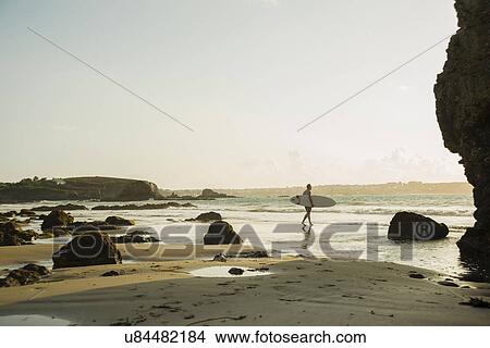 Mature man walking towards sea, holding surf board View Large Photo Image Picture - Mature man walking towards sea, holding surf board. Fotosearch