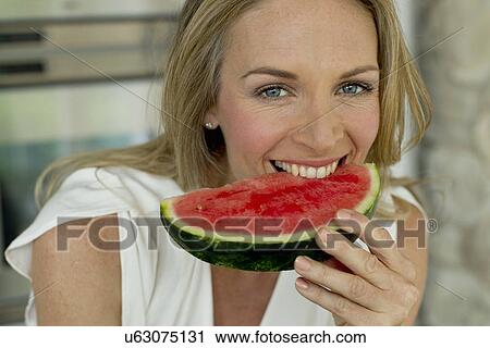 Mature woman biting watermelon View Large Photo Image Stock Image - Mature woman biting watermelon. Fotosearch