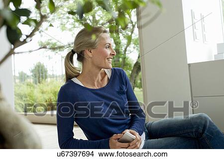 Picture - Mature woman holding cell phone. Fotosearch