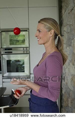 Stock Photo - Mature woman juggling tomatoes. Fotosearch