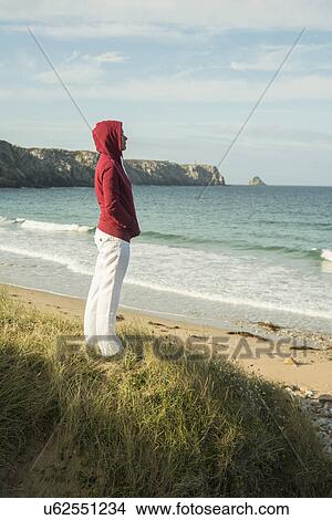 Picture - Mature woman standing gazing at sea view, Camaret-sur-mer, Brittany, France. Fotosearch