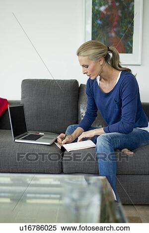 Stock Photography - Mature woman working from home. Fotosearch