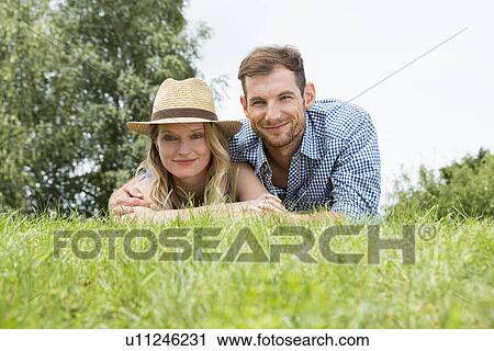 Mid adult couple lying on grass, portrait View Large Photo Image Stock Image - Mid adult couple lying on grass, portrait. Fotosearch
