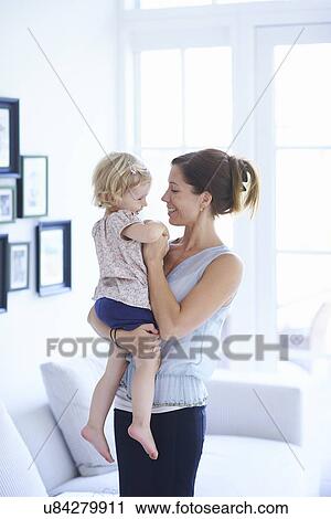 Mid adult woman and toddler daughter in living room View Large Photo Image Stock Image - Mid adult woman and toddler daughter in living room. Fotosearch