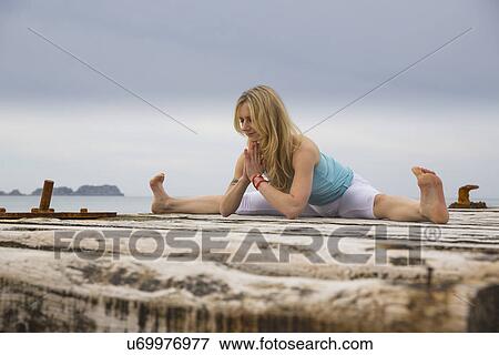 Mid adult woman with hands together practicing yoga on wooden sea pier View Large Photo Image Stock Photo - Mid adult woman with hands together practicing yoga on wooden sea pier. Fotosearch
