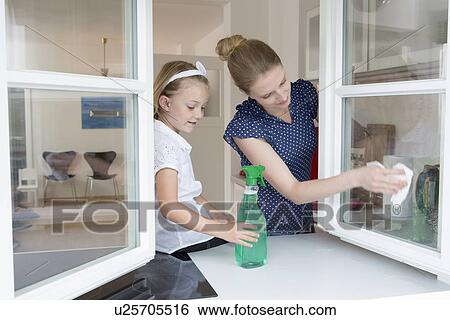 Mother and daughter cleaning window View Large Photo Image Stock Photograph - Mother and daughter cleaning window. Fotosearch