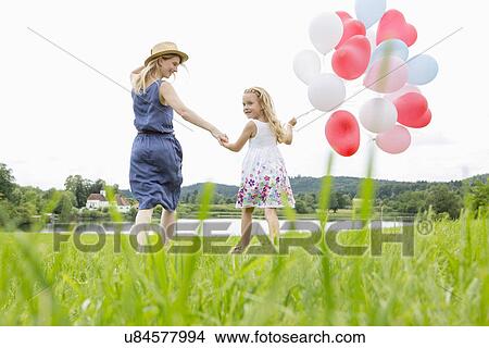 Mother and daughter in field with balloons View Large Photo Image Picture - Mother and daughter in field with balloons. Fotosearch