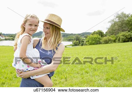 Mother holding daughter in field, portrait View Large Photo Image Picture - Mother holding daughter in field, portrait. Fotosearch